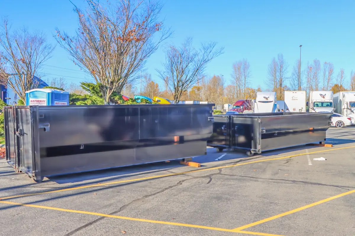 Professional dumpster rental service with roll-off container on residential driveway in Pomfret